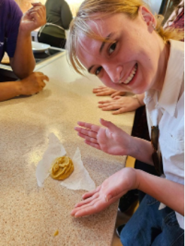 Isabelle and her baking creation, an orange cookie replica of the Agamemnon Mask, Zotos Brothers Biofarm